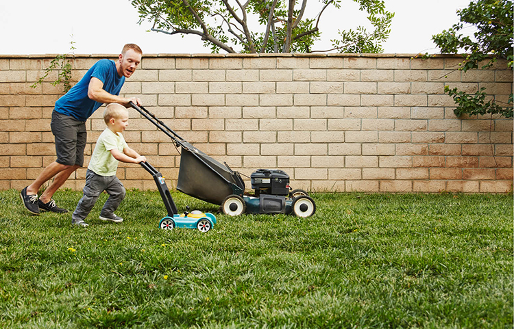 Father and son mowing the lawn